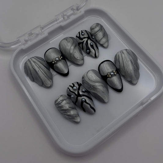 Extensions d'ongles press on Joy Chrome 3D de Onailsbymanon, finition chromée brillante et design en relief 3D.