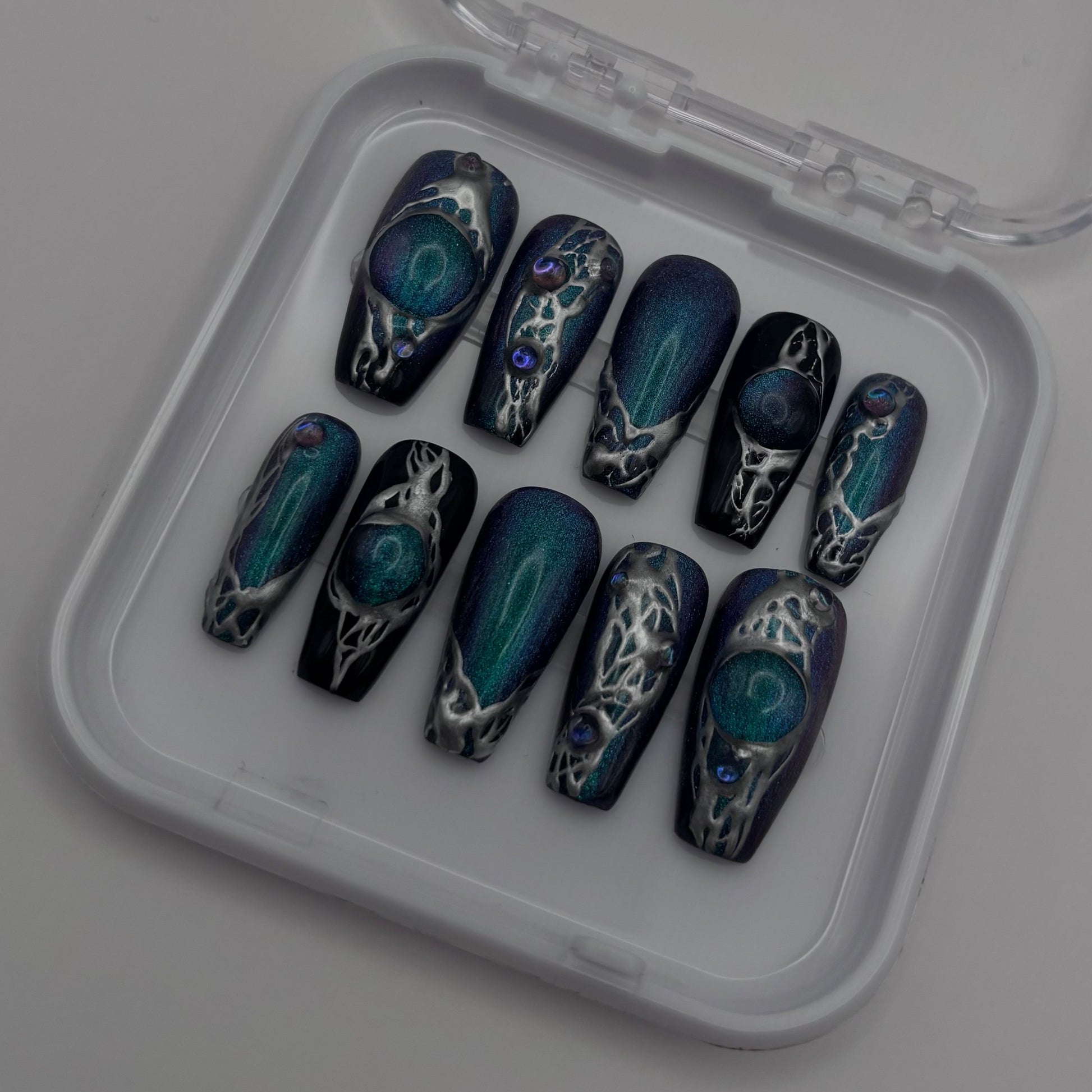 Limage montre des faux ongles press-on Esmee en chrome à yeux de chat, de la marque Onailsbymanon, avec finition brillante et élégante.