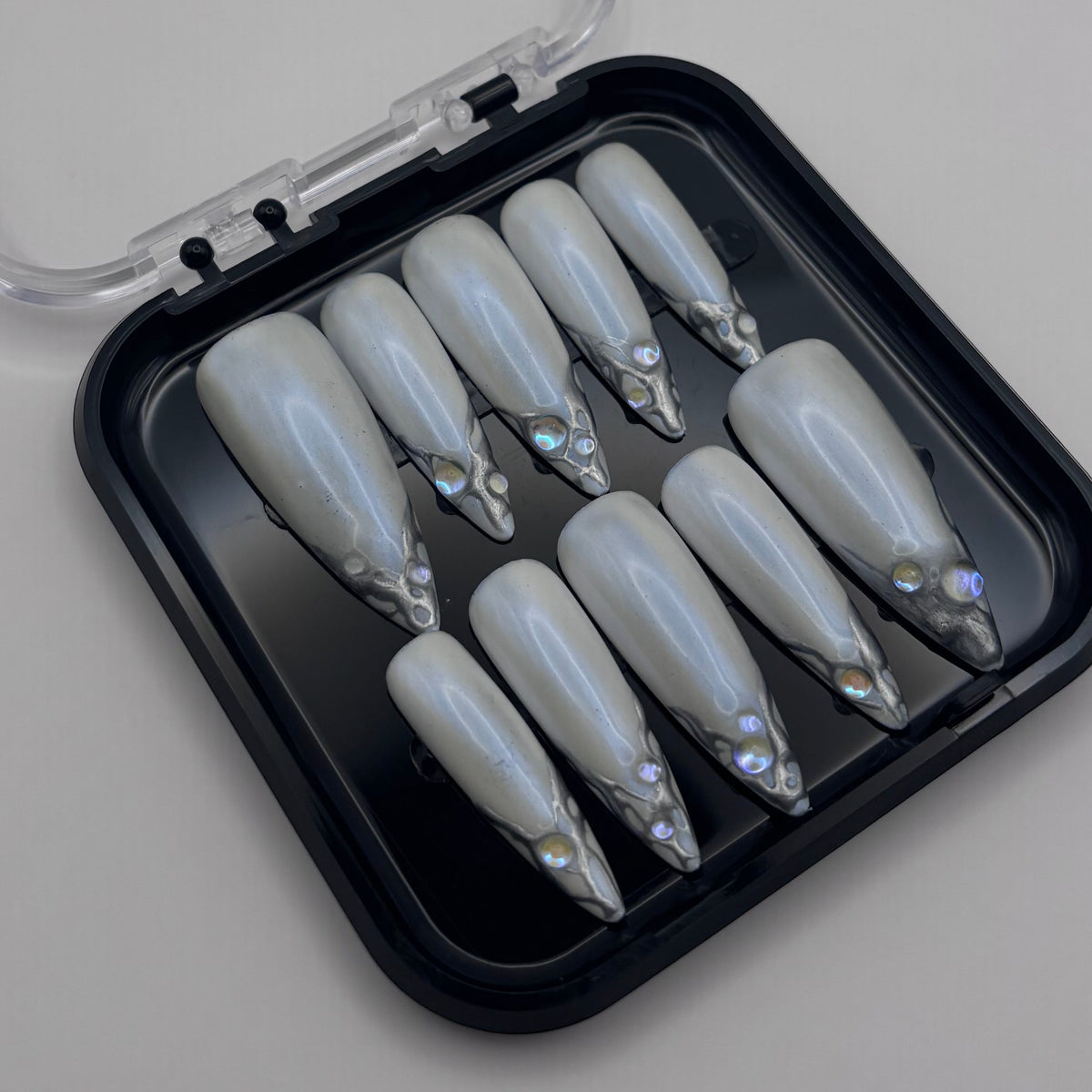 Press-on ongles Amelia en chrome 3D de la marque Onailsbymanon, avec finition brillante et design élégant.