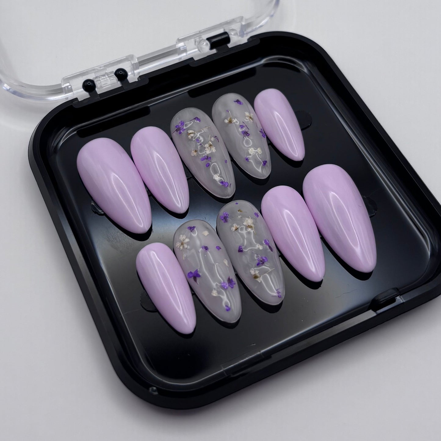 Extensions d'ongles press on Lila Floral Glossy de Onailsbymanon, finition brillante et élégante, visibles dans l'image.
